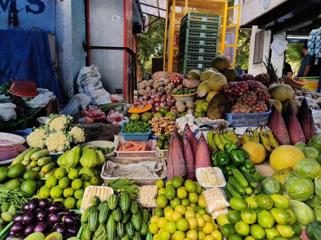 Colorful display of fresh fruits and vegetables arranged at a street market stall.